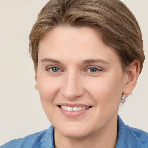 Joyful white young-adult female with short  brown hair and grey eyes