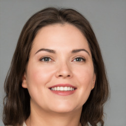 Joyful white young-adult female with medium  brown hair and grey eyes