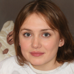 Joyful white young-adult female with medium  brown hair and blue eyes