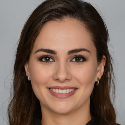 Joyful white young-adult female with long  brown hair and brown eyes