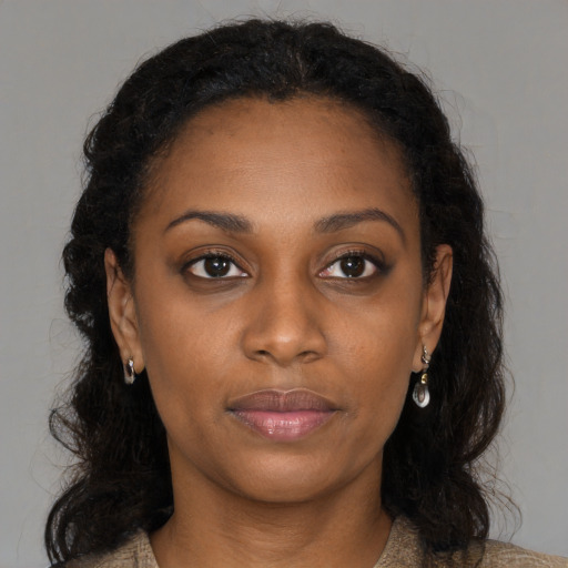 Joyful black young-adult female with long  brown hair and brown eyes
