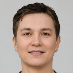 Joyful white young-adult male with short  brown hair and grey eyes