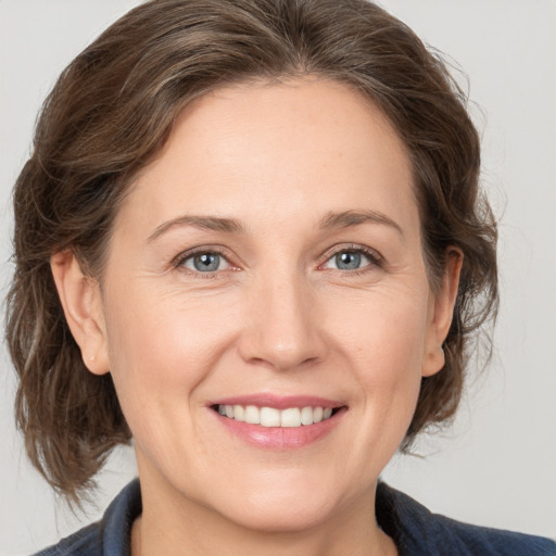 Joyful white adult female with medium  brown hair and grey eyes