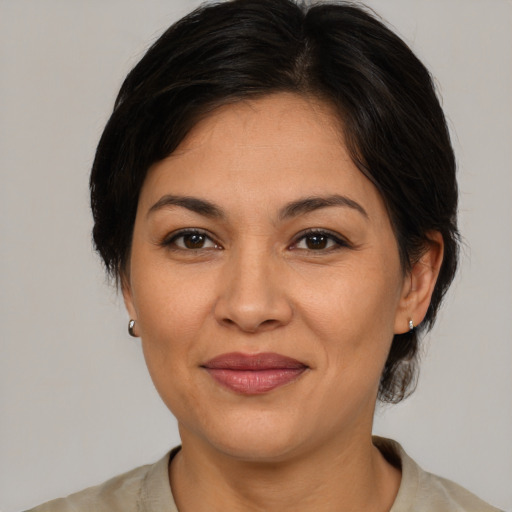 Joyful latino adult female with medium  brown hair and brown eyes