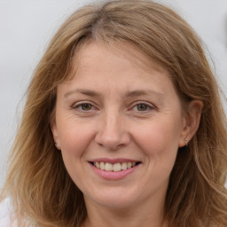 Joyful white adult female with long  brown hair and brown eyes