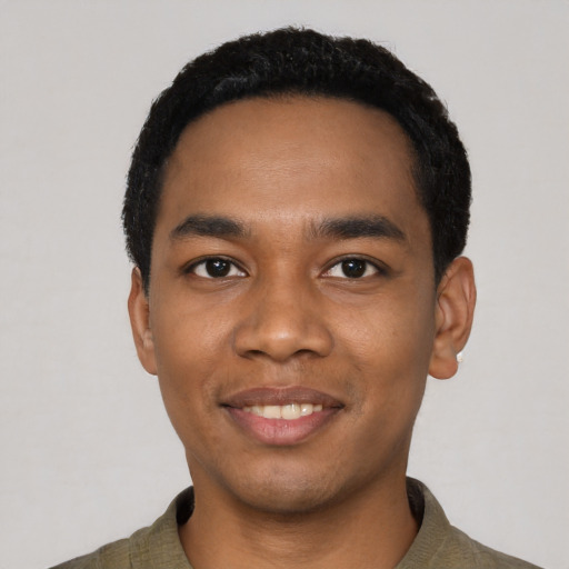 Joyful black young-adult male with short  black hair and brown eyes