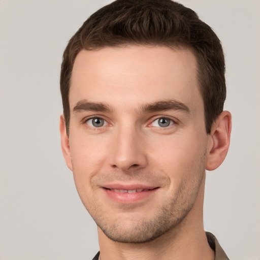 Joyful white young-adult male with short  brown hair and grey eyes