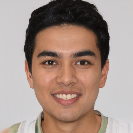 Joyful latino young-adult male with short  black hair and brown eyes