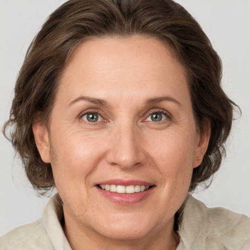 Joyful white adult female with medium  brown hair and grey eyes