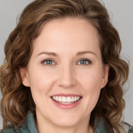 Joyful white young-adult female with long  brown hair and blue eyes