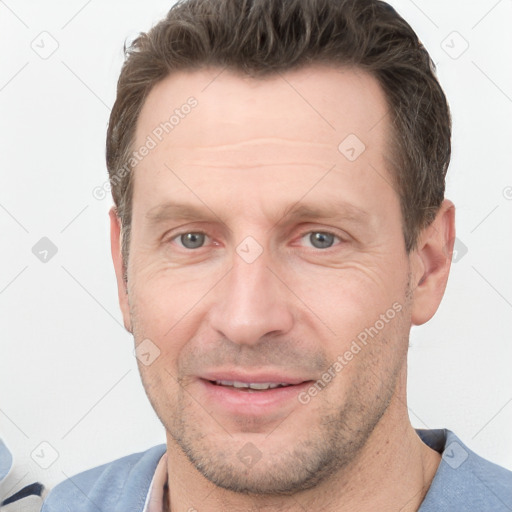 Joyful white adult male with short  brown hair and grey eyes