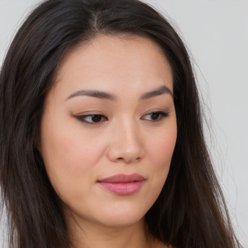 Joyful asian young-adult female with long  brown hair and brown eyes
