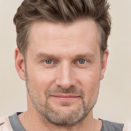 Joyful white adult male with short  brown hair and grey eyes