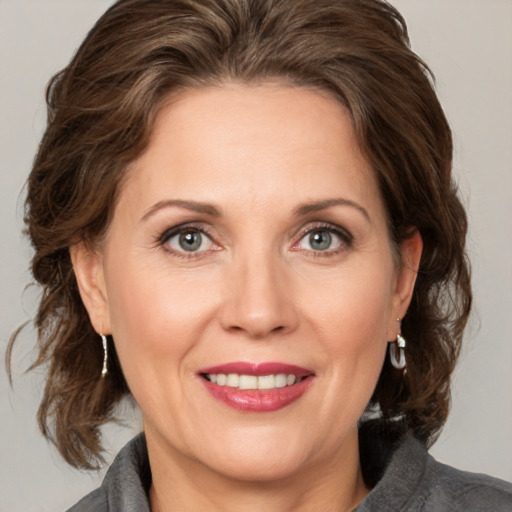 Joyful white adult female with medium  brown hair and grey eyes