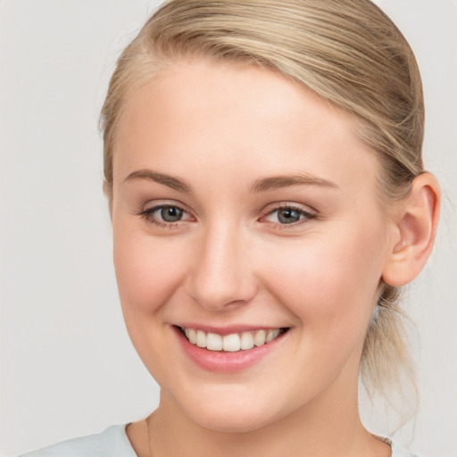 Joyful white young-adult female with medium  brown hair and blue eyes