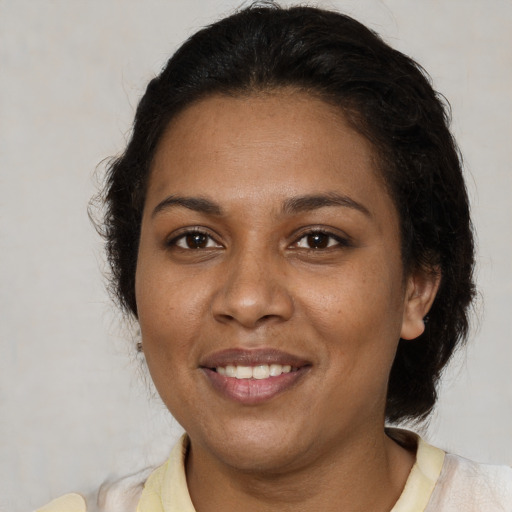 Joyful black adult female with medium  brown hair and brown eyes