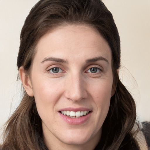 Joyful white young-adult female with long  brown hair and grey eyes