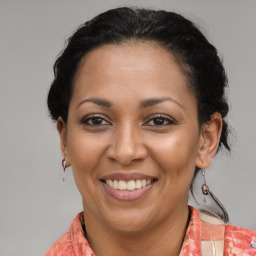 Joyful latino adult female with medium  brown hair and brown eyes