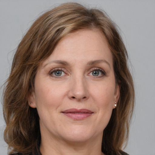 Joyful white adult female with medium  brown hair and grey eyes