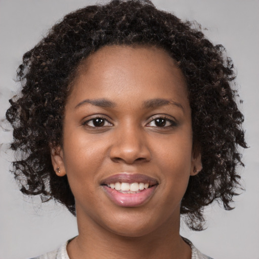 Joyful black young-adult female with medium  brown hair and brown eyes
