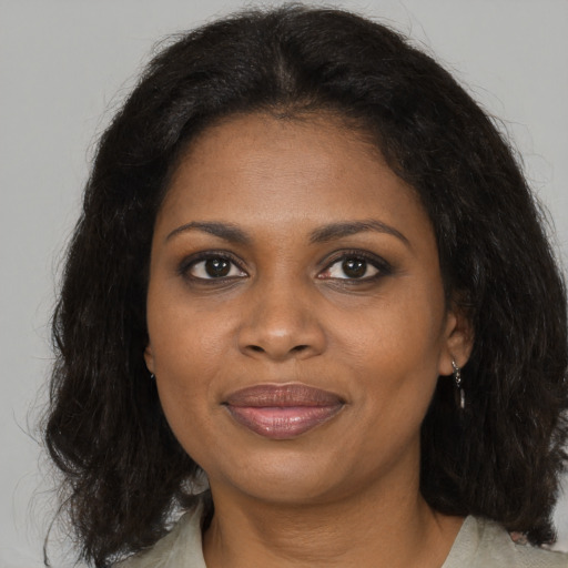 Joyful black adult female with medium  brown hair and brown eyes