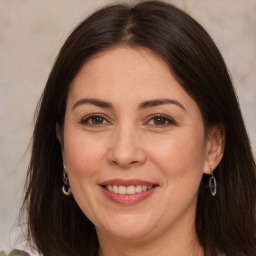 Joyful white adult female with long  brown hair and brown eyes