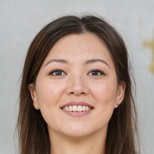 Joyful white young-adult female with long  brown hair and brown eyes