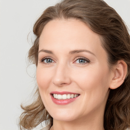 Joyful white young-adult female with long  brown hair and green eyes