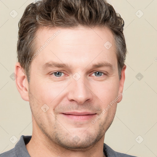 Joyful white adult male with short  brown hair and grey eyes