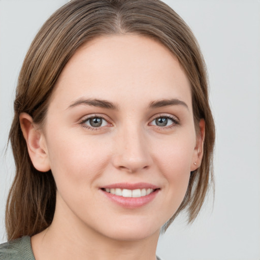 Joyful white young-adult female with medium  brown hair and grey eyes