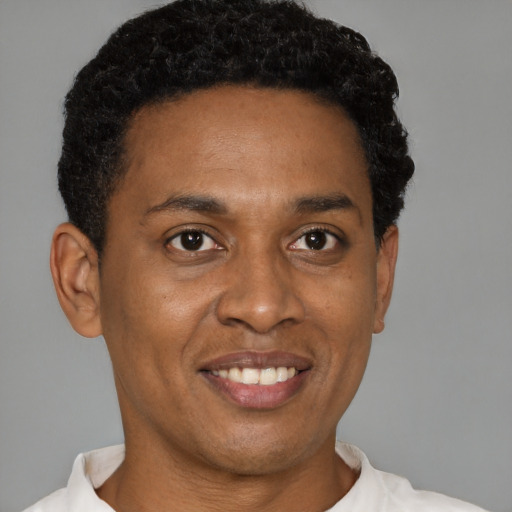 Joyful latino young-adult male with short  brown hair and brown eyes