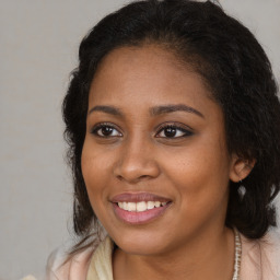 Joyful black young-adult female with long  brown hair and brown eyes