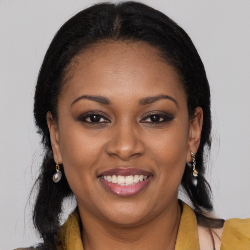 Joyful black young-adult female with long  black hair and brown eyes