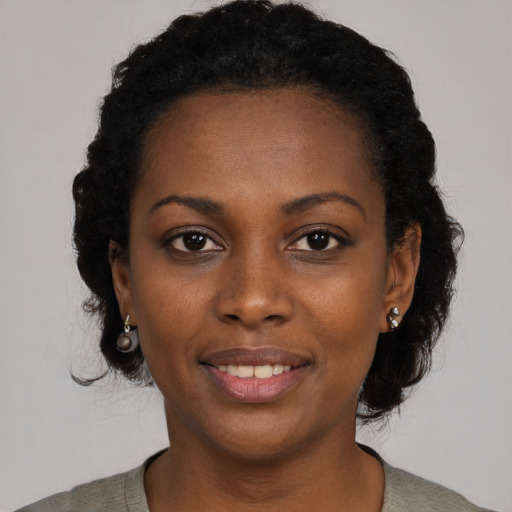 Joyful black young-adult female with medium  black hair and brown eyes