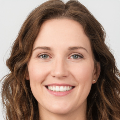 Joyful white young-adult female with long  brown hair and green eyes