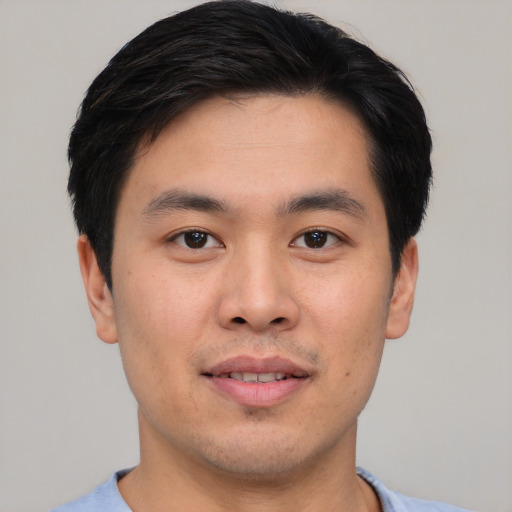 Joyful asian young-adult male with short  black hair and brown eyes