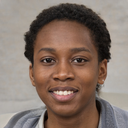 Joyful black young-adult female with short  brown hair and brown eyes