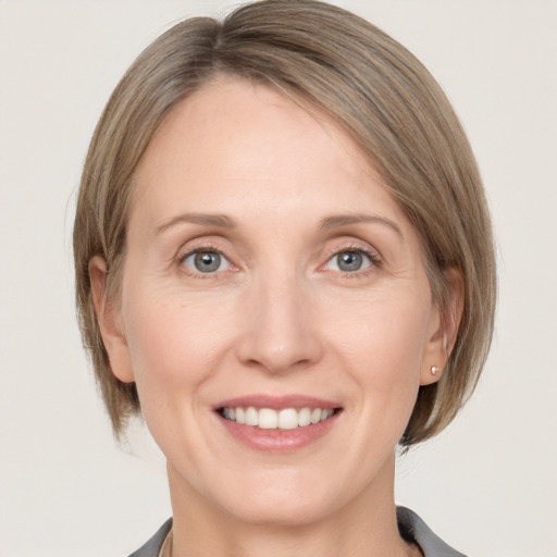 Joyful white adult female with medium  brown hair and grey eyes