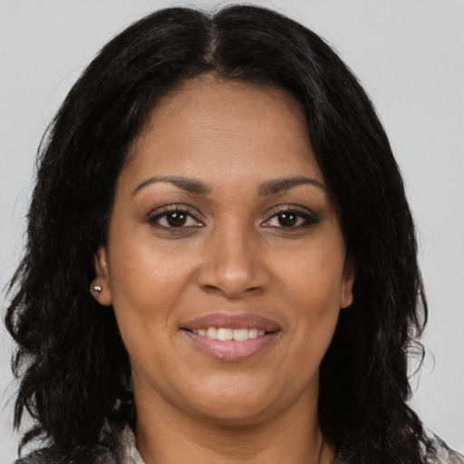 Joyful black young-adult female with long  brown hair and brown eyes