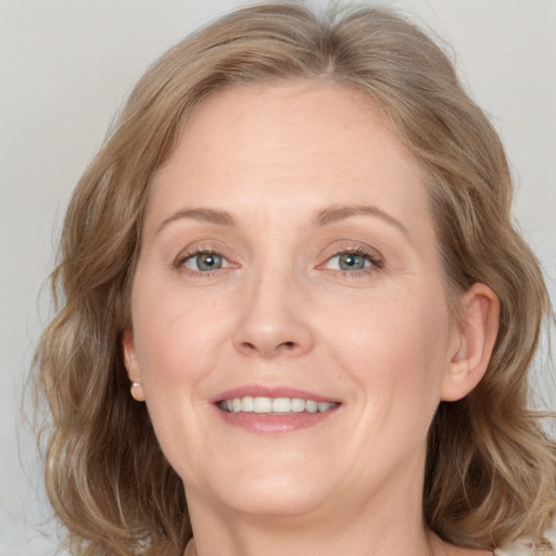 Joyful white adult female with medium  brown hair and grey eyes