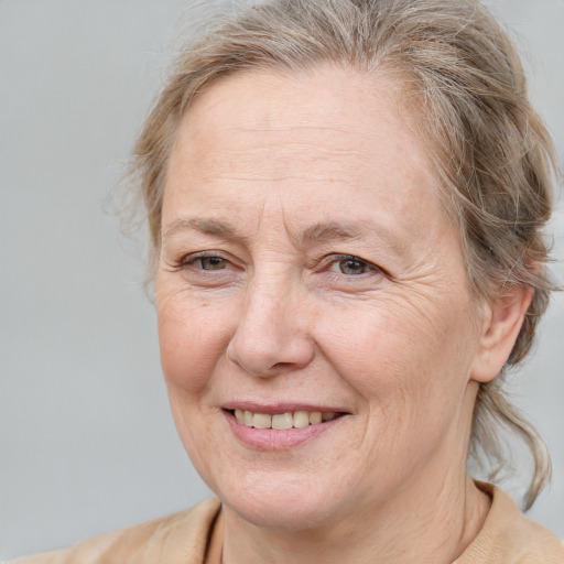 Joyful white middle-aged female with medium  brown hair and blue eyes