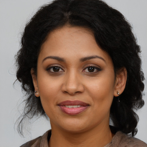 Joyful latino adult female with long  brown hair and brown eyes