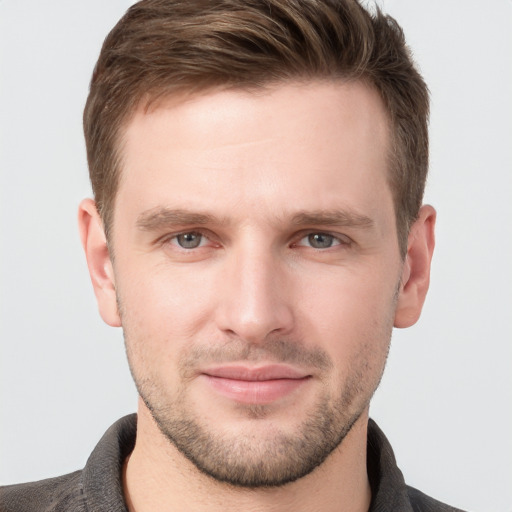 Joyful white young-adult male with short  brown hair and grey eyes