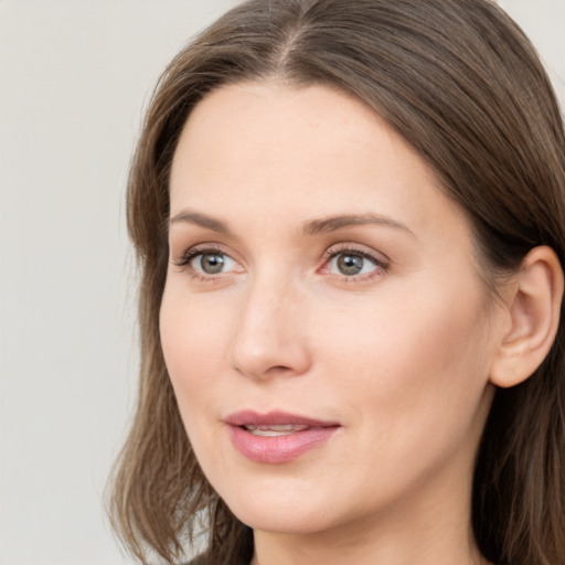 Joyful white young-adult female with long  brown hair and grey eyes