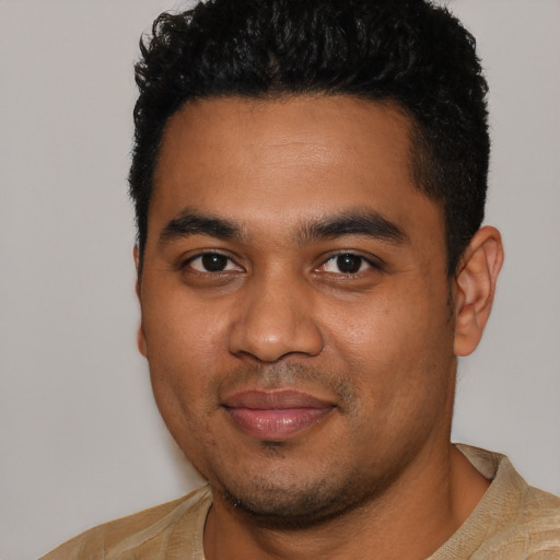 Joyful black young-adult male with short  black hair and brown eyes
