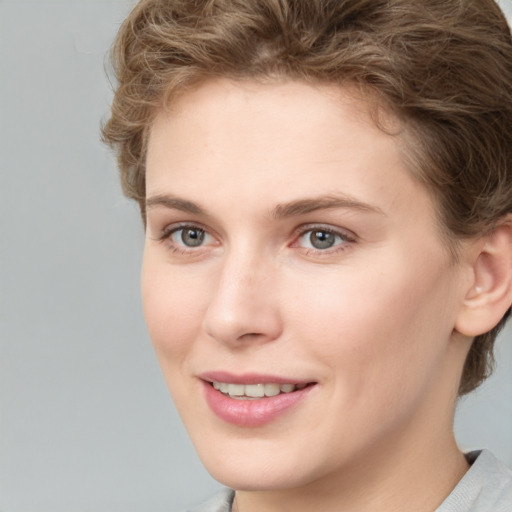 Joyful white young-adult female with short  brown hair and grey eyes