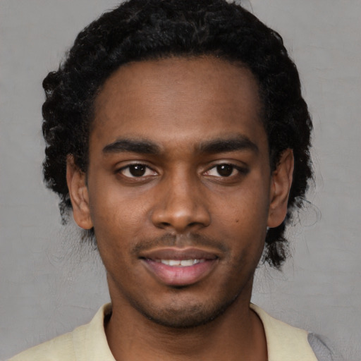 Joyful black young-adult male with short  black hair and brown eyes