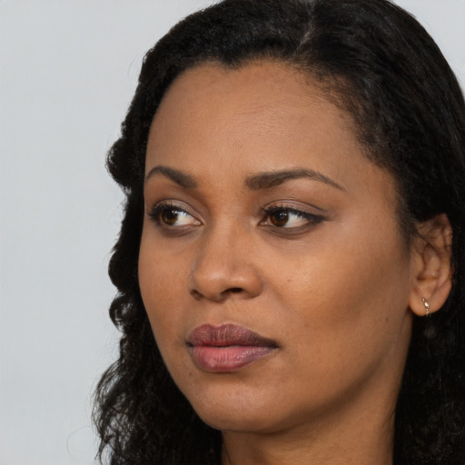 Joyful black young-adult female with long  black hair and brown eyes