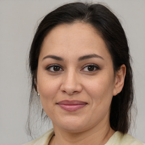 Joyful latino adult female with medium  brown hair and brown eyes