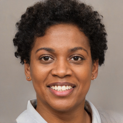 Joyful black young-adult female with short  brown hair and brown eyes